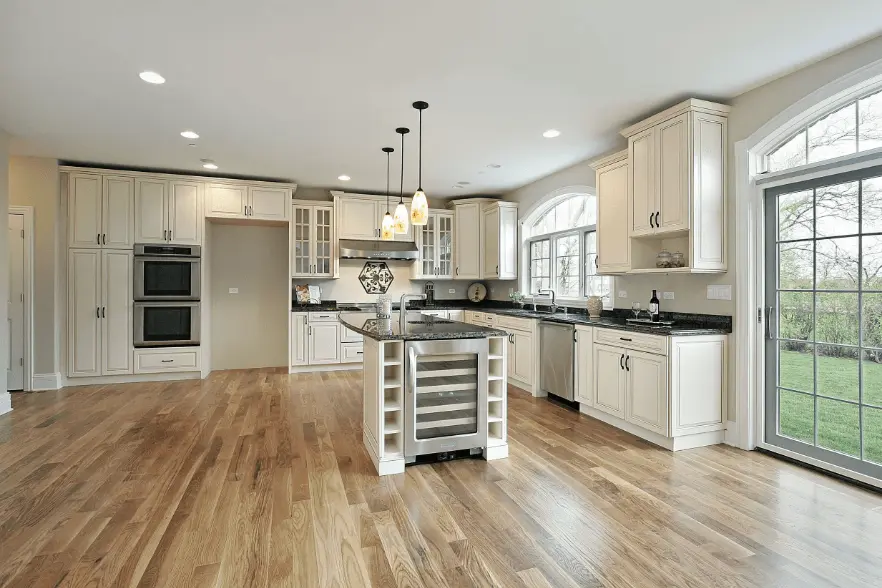 Solid hardwood boards installed over a wood subfloor in a bright kitchen