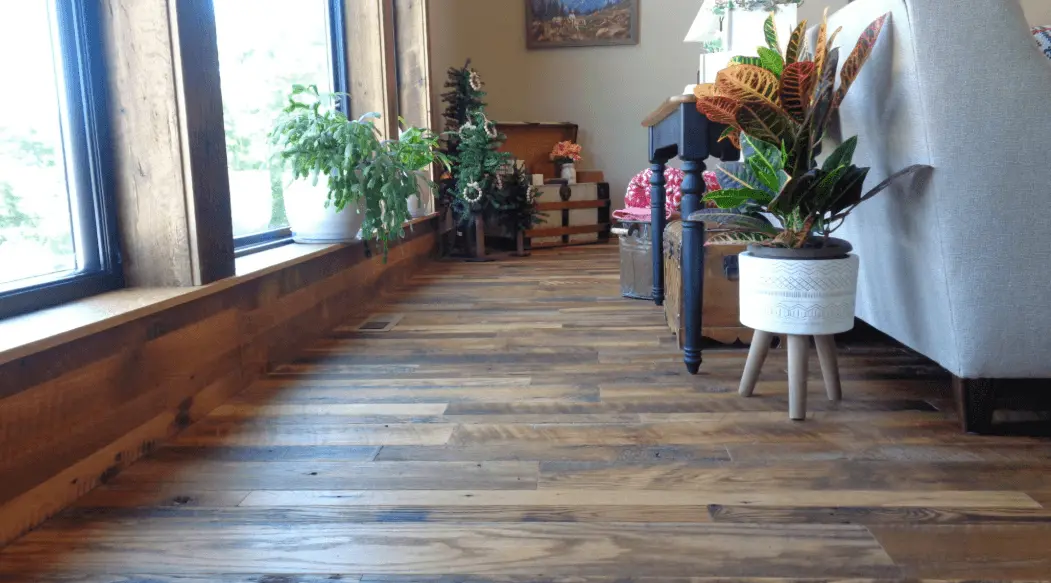 Reclaimed rustic wood flooring with nail holes, knots, and mixed board lengths